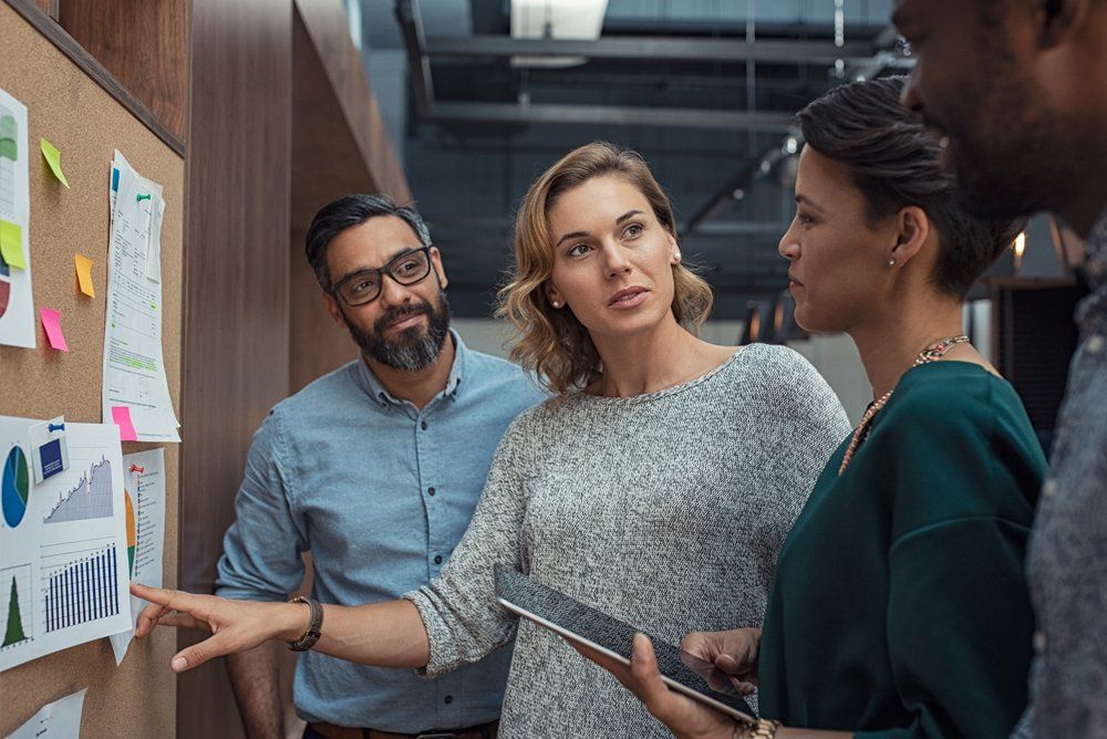 A group of people are looking at a bulletin board.