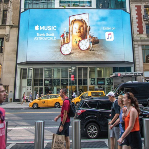 A large billboard on the side of a building advertises apple music