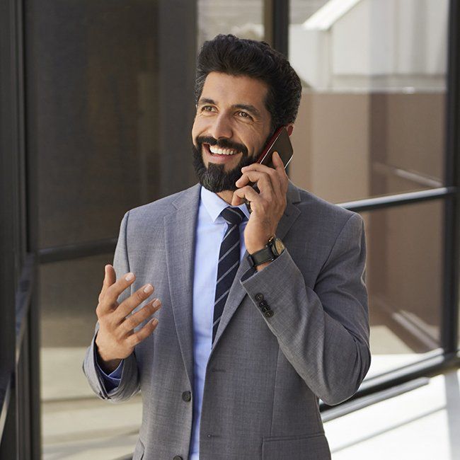 A man in a suit and tie is talking on a cell phone