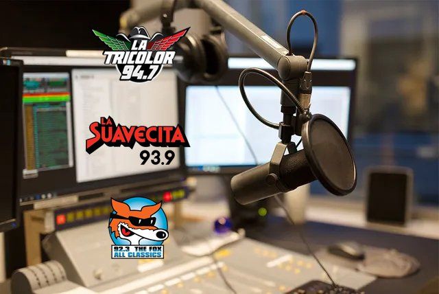 A microphone is sitting in front of a monitor that says suavecita 93.9