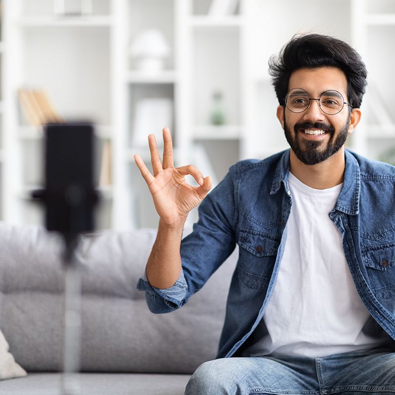 Man with beard and glasses doin ok with his hand