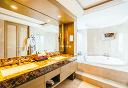 Hands testing wires with a multimeter on a white terminal block on a wooden surface.
