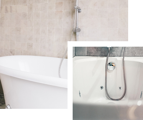 White bathtub with shower fixtures against light tile wall.