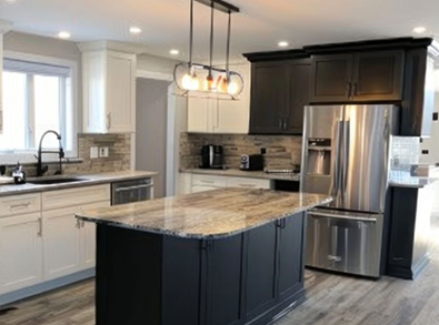 Modern kitchen with dark island and black and white cabinets, granite countertops, and stainless steel appliances.