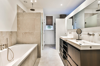 Modern bathroom with a bathtub, shower, double vanity, and a window with a brown shade.