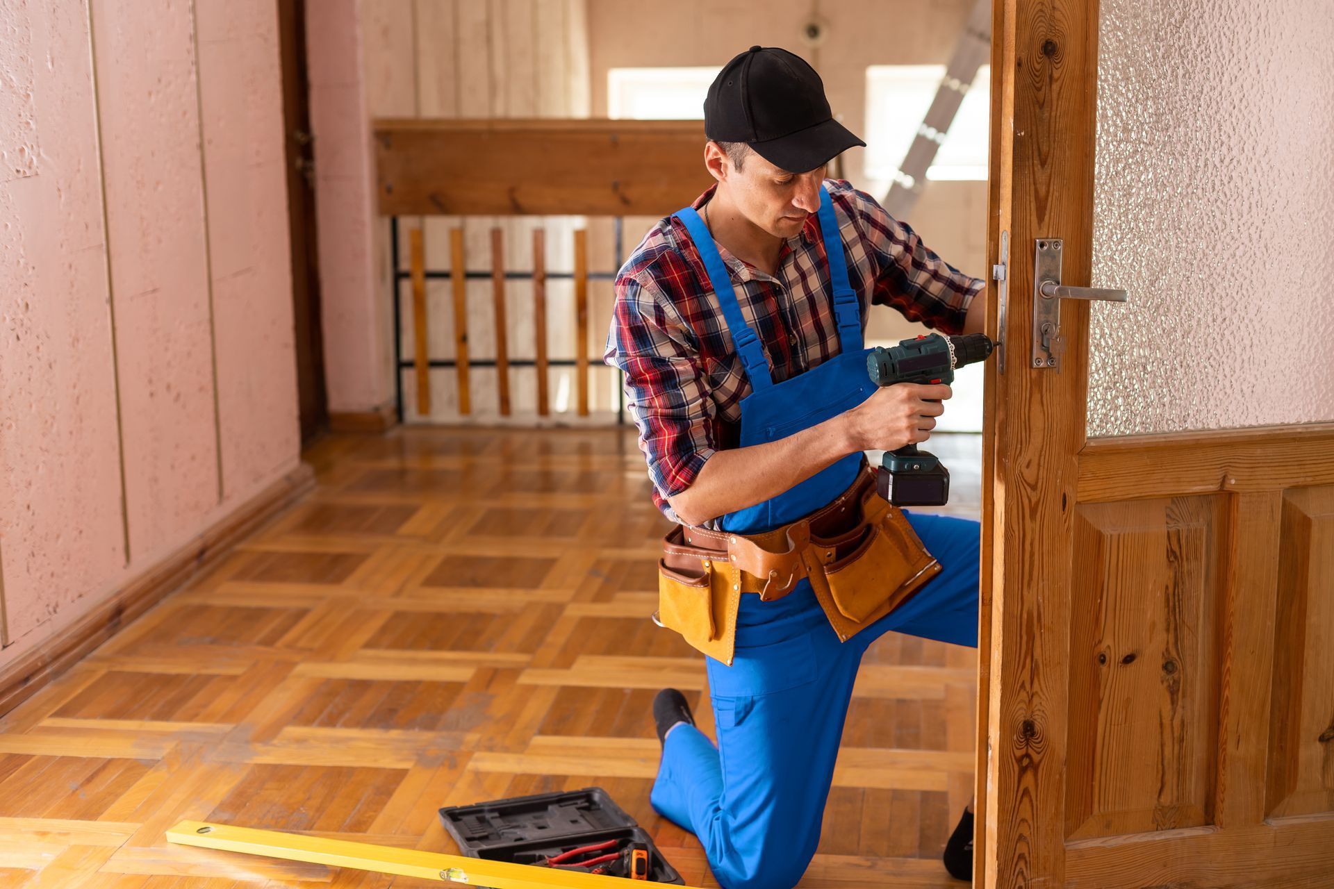 Man using a bow saw to cut wood in a workshop with tools and wood shavings.