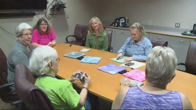 A group of women are sitting around a table in a conference room.