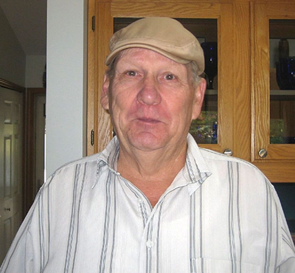 A man wearing a hat and a striped shirt