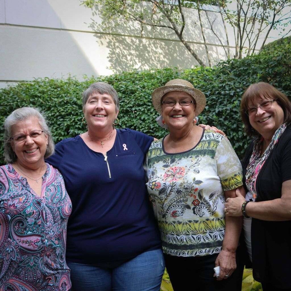 A group of four women are posing for a picture together