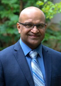 A man in a suit and tie is smiling for the camera.