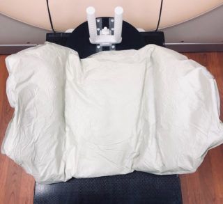 A white blanket is sitting on top of a chair