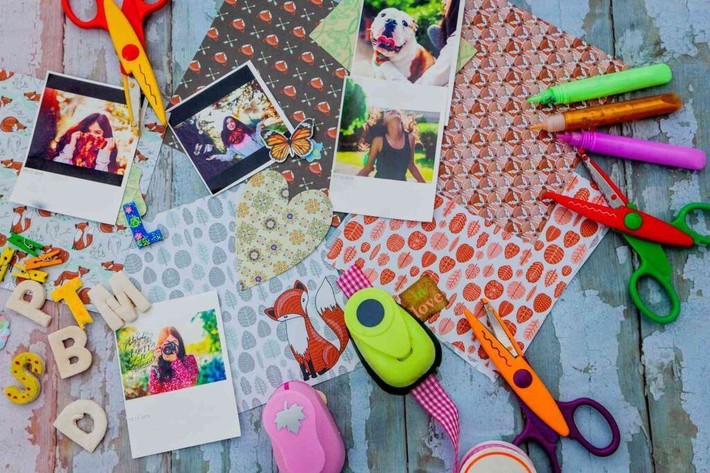 A wooden table topped with a variety of craft supplies.