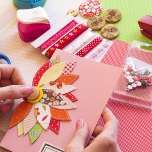 A person is holding a pink card with a flower on it