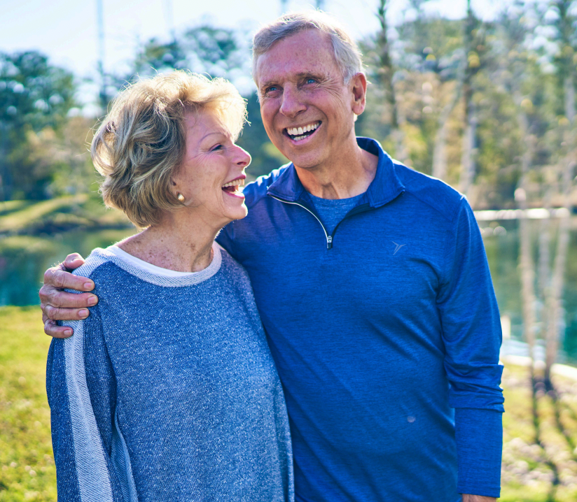 A man and a woman are standing next to each other and smiling.