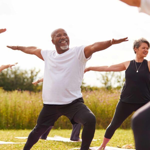 A group of people are practicing yoga in a field