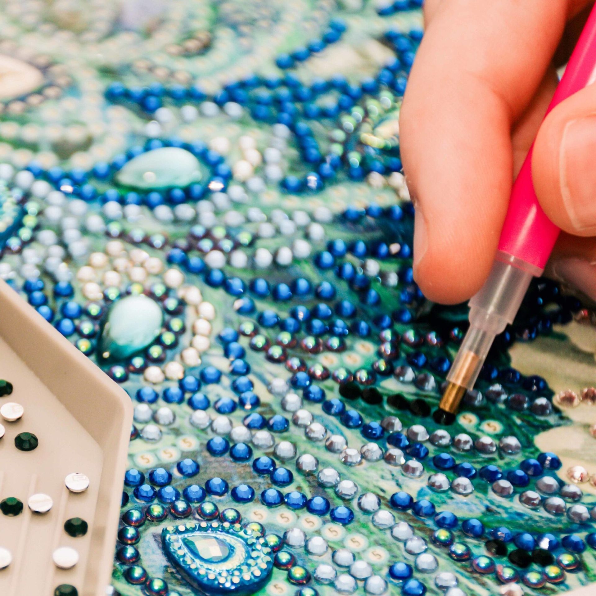 A person is painting a peacock with a pen.