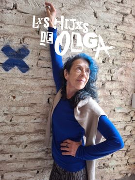 Una persona con el pelo azul y una camisa azul de manga larga está de pie contra una pared de ladrillos, con el brazo levantado y el título superpuesto.