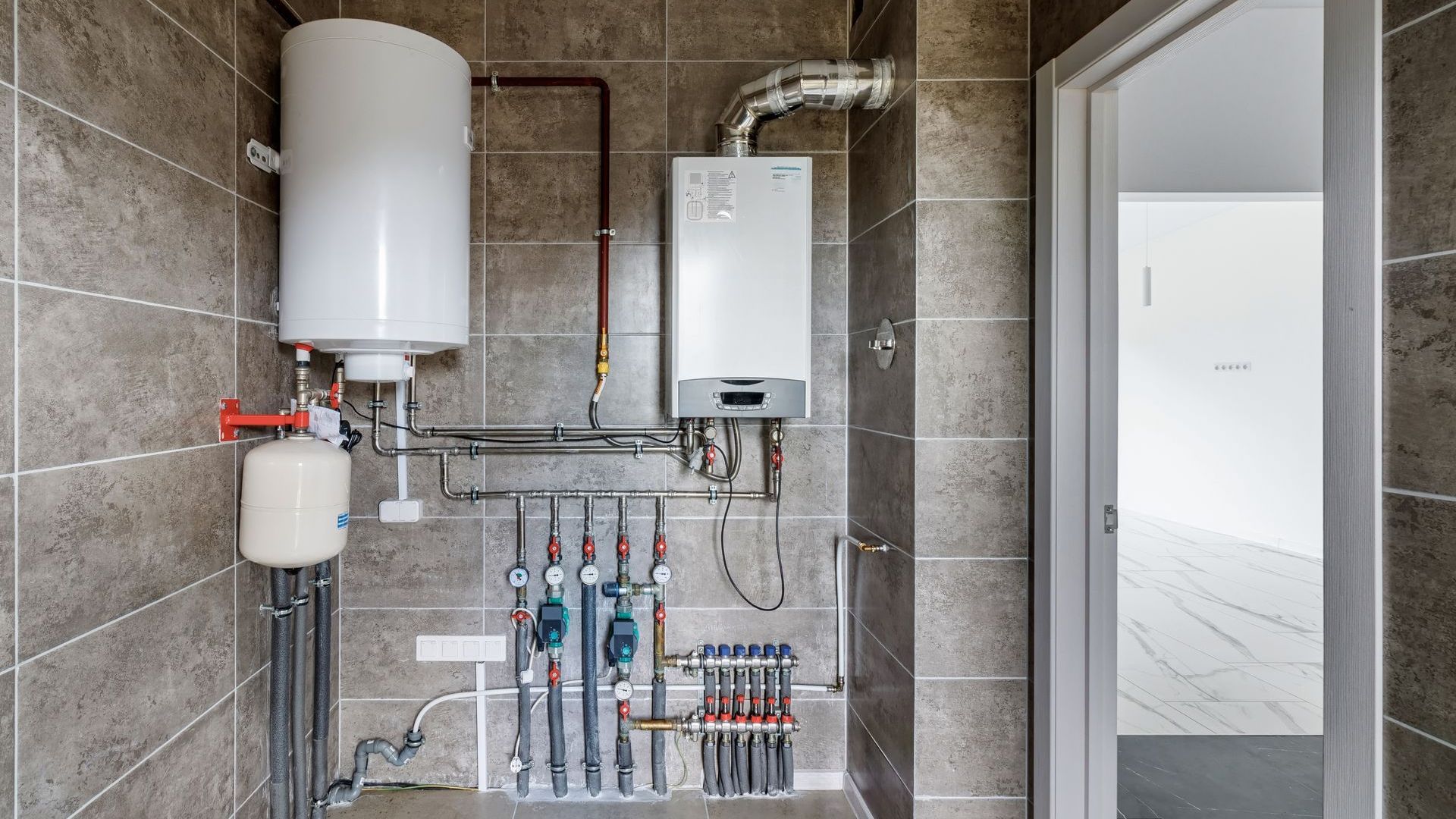 A bathroom with a water heater and a boiler.
