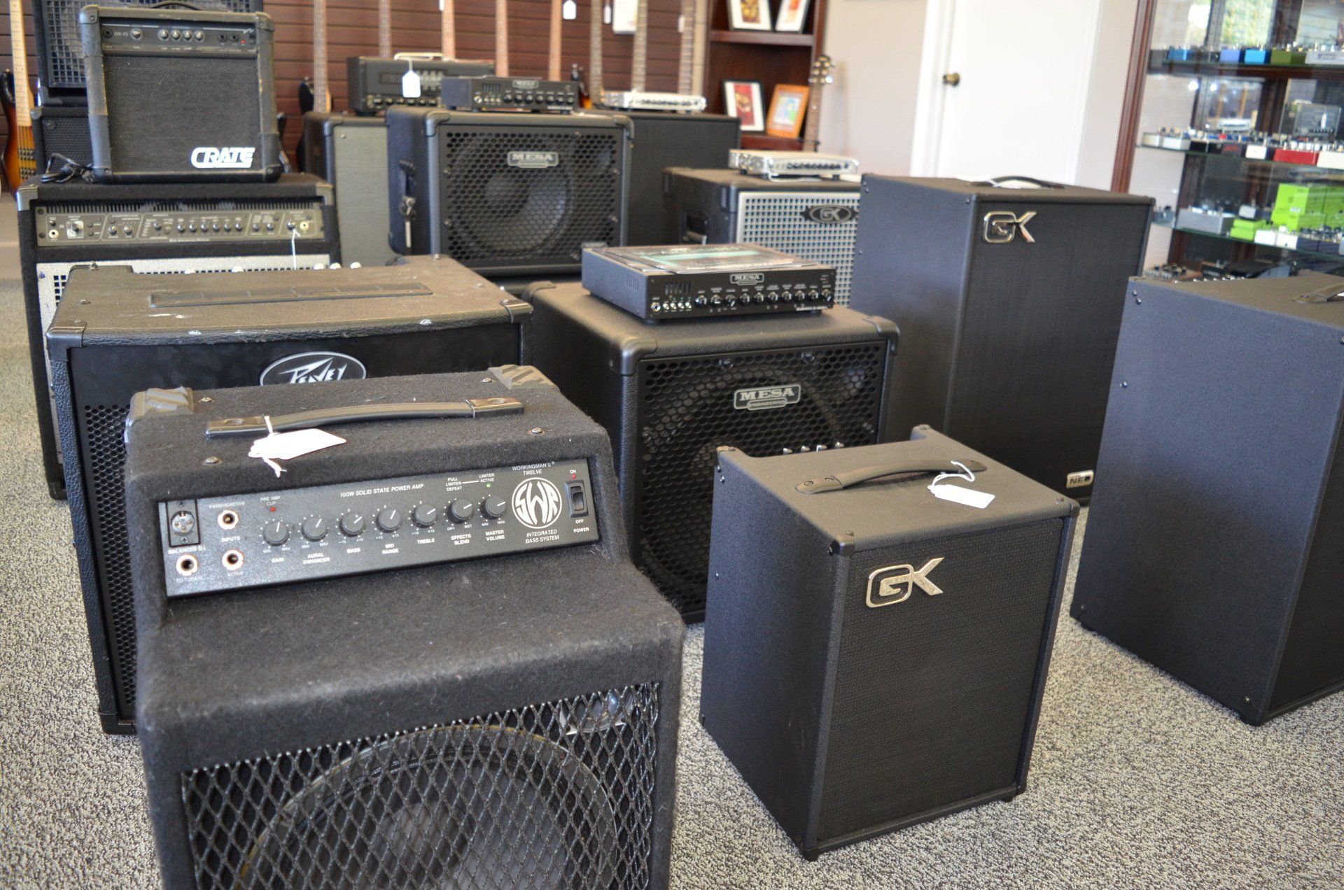 Collection of black guitar amplifiers displayed in a store setting.