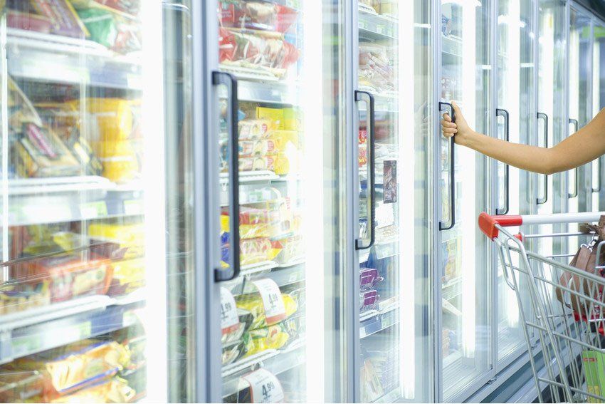 Mixed race woman shopping in frozen food aisle