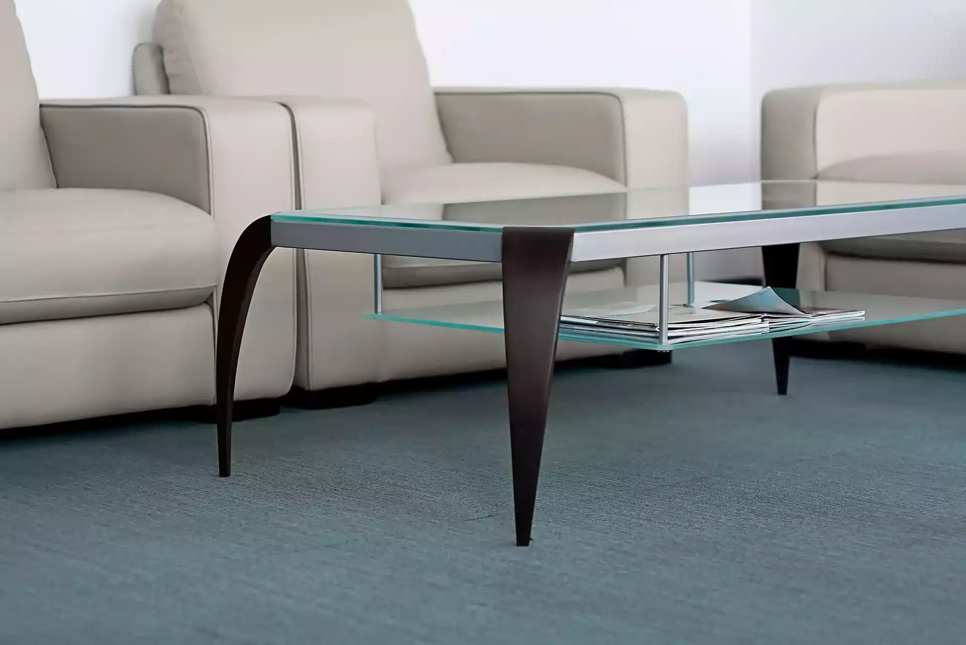 a glass coffee table with magazines on it in a living room