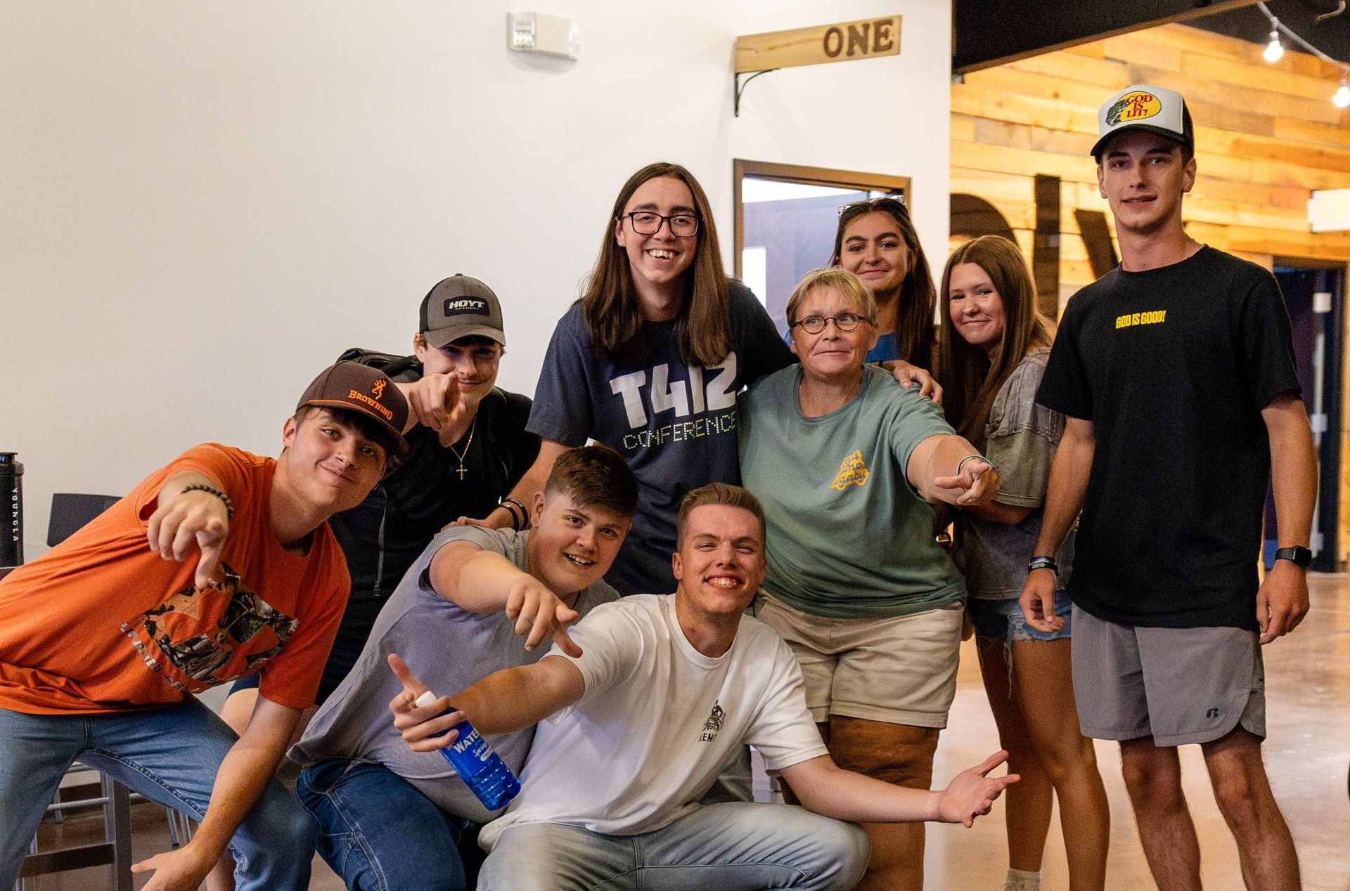 A group of young men are posing for a picture in front of a worship center.
