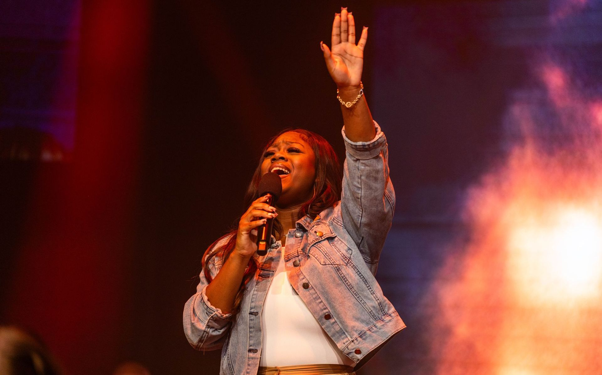 A woman is singing into a microphone on a stage.