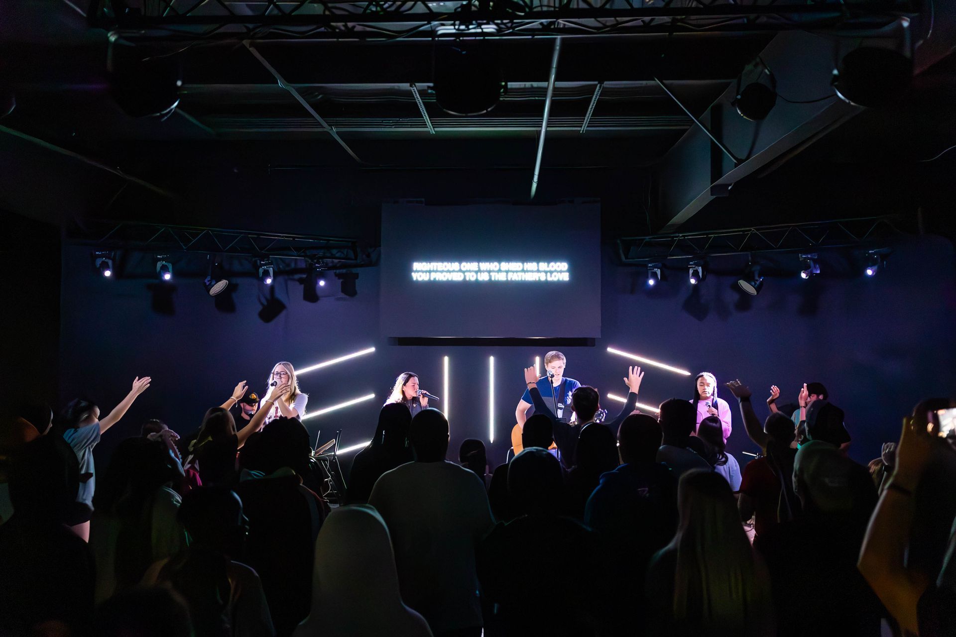 A group of young men are posing for a picture in front of a worship center.