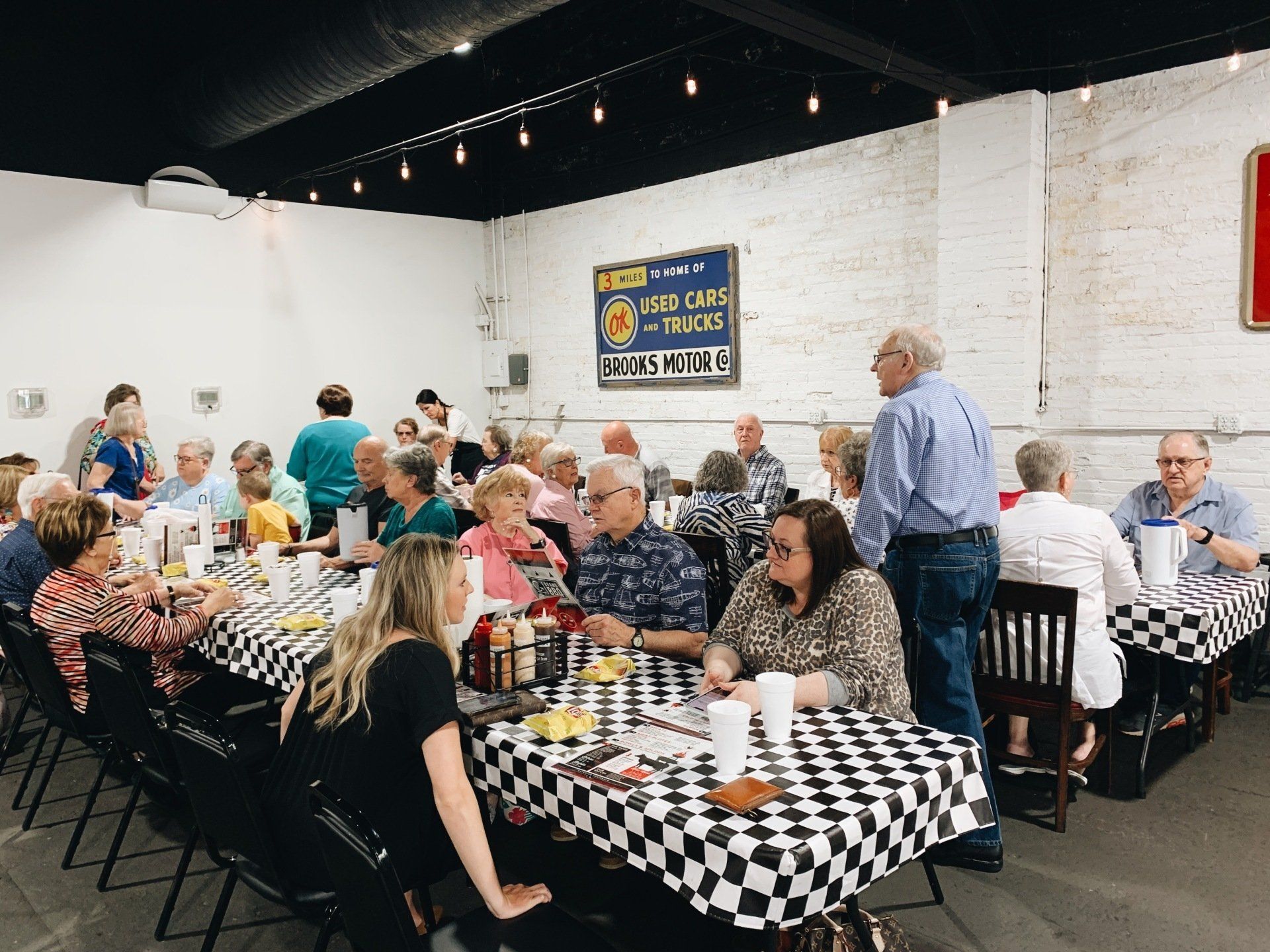 A group of people are sitting at tables in a restaurant.