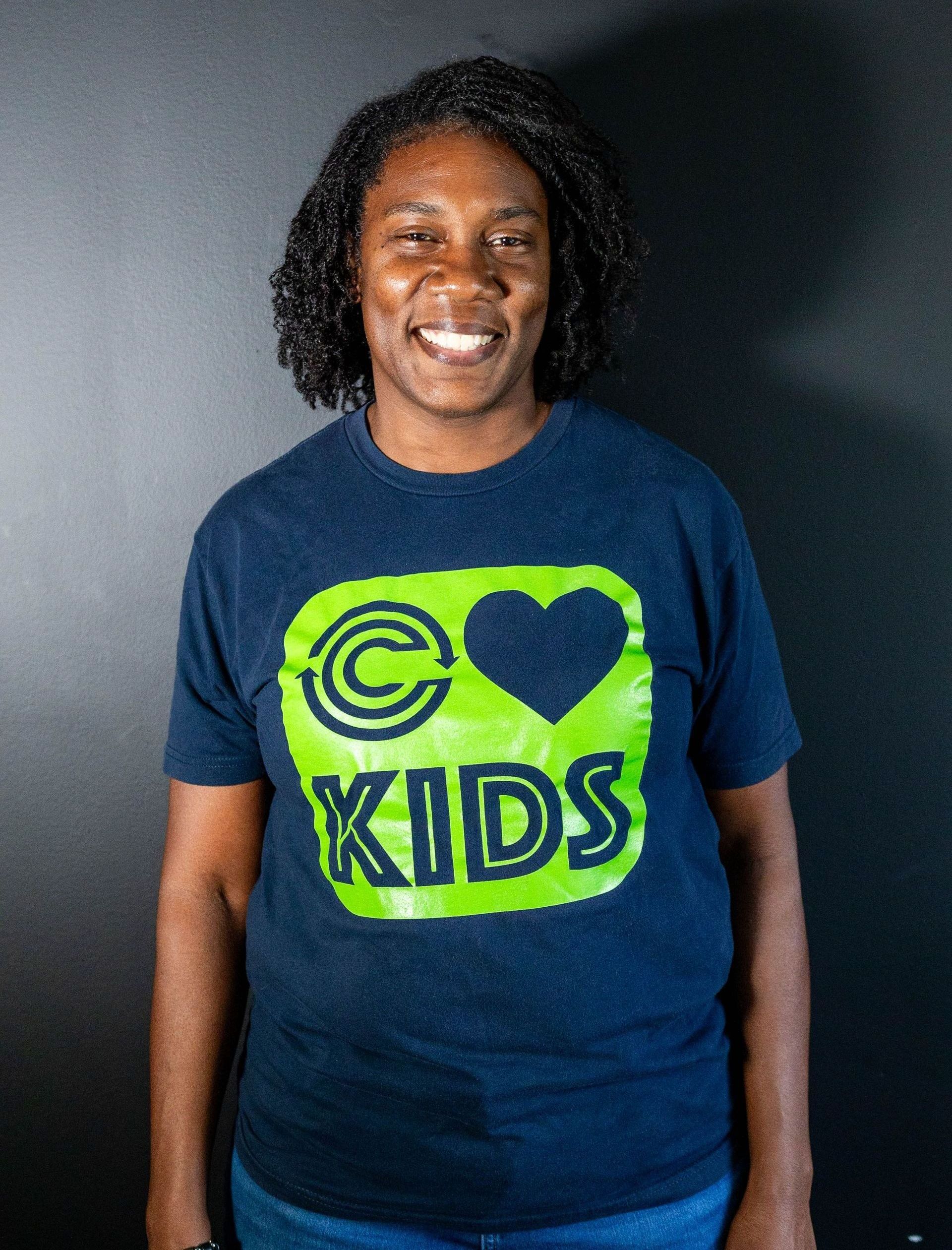 A woman in a blue floral dress is smiling for the camera.