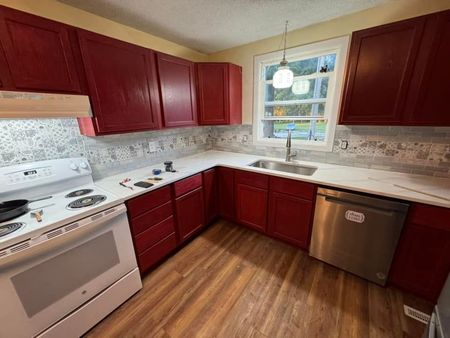 A kitchen with red cabinets and white appliances A kitchen with red cabinets and white appliances