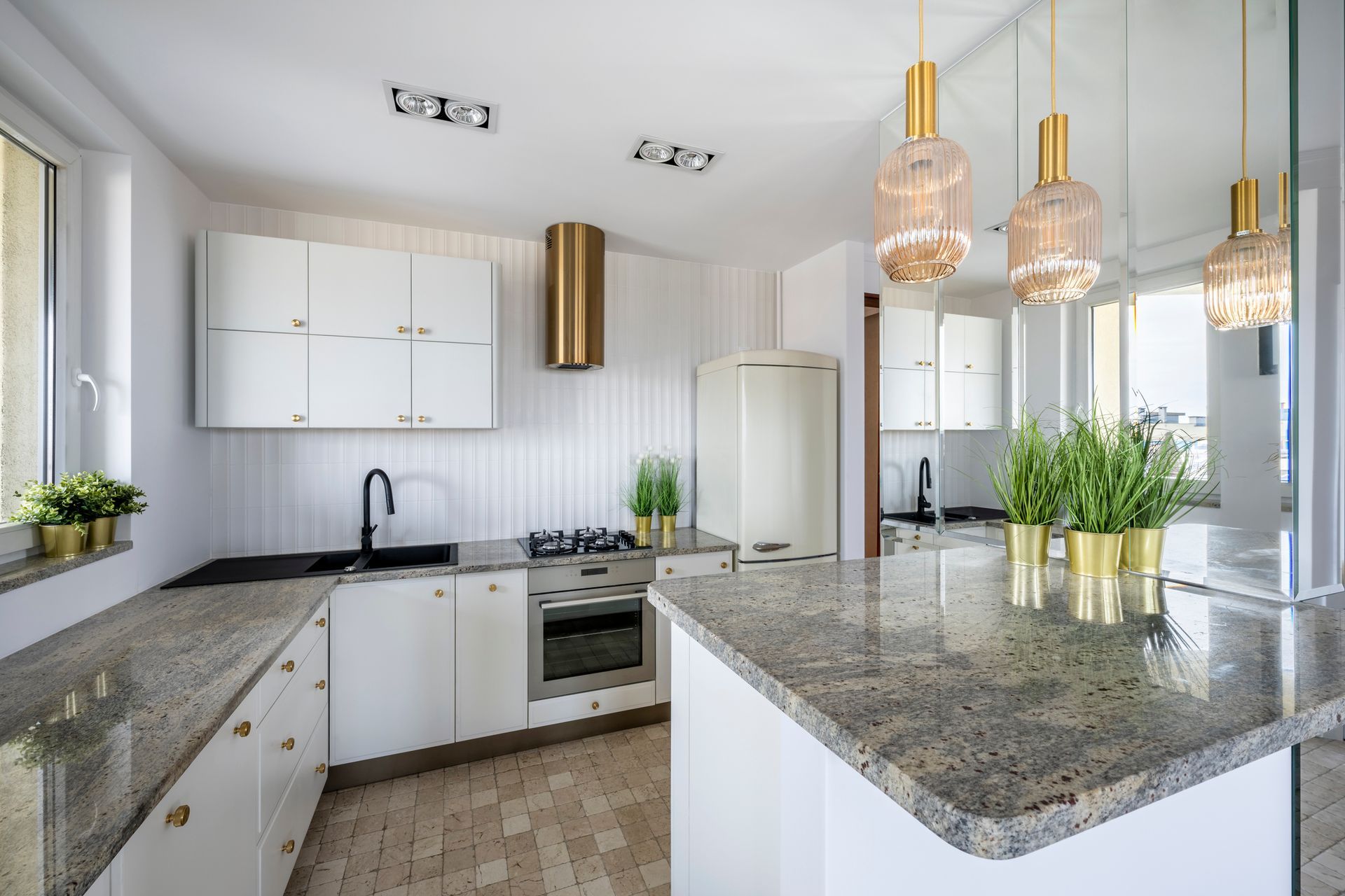 A kitchen with granite counter tops and white cabinets.