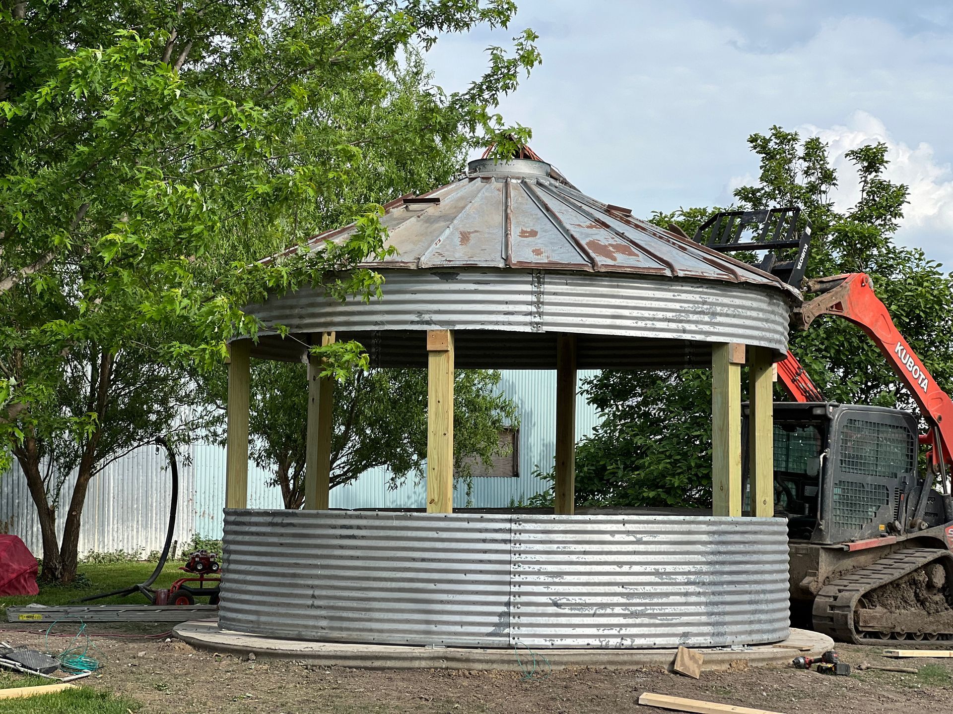 There is a patio with a pergola and a couch underneath it.