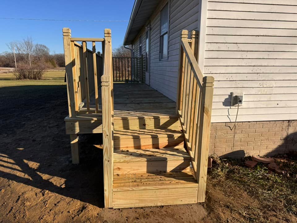 A white house with a wooden deck and stairs
