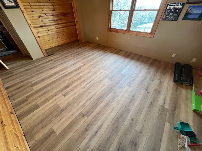 A room with a wooden floor and a window.
