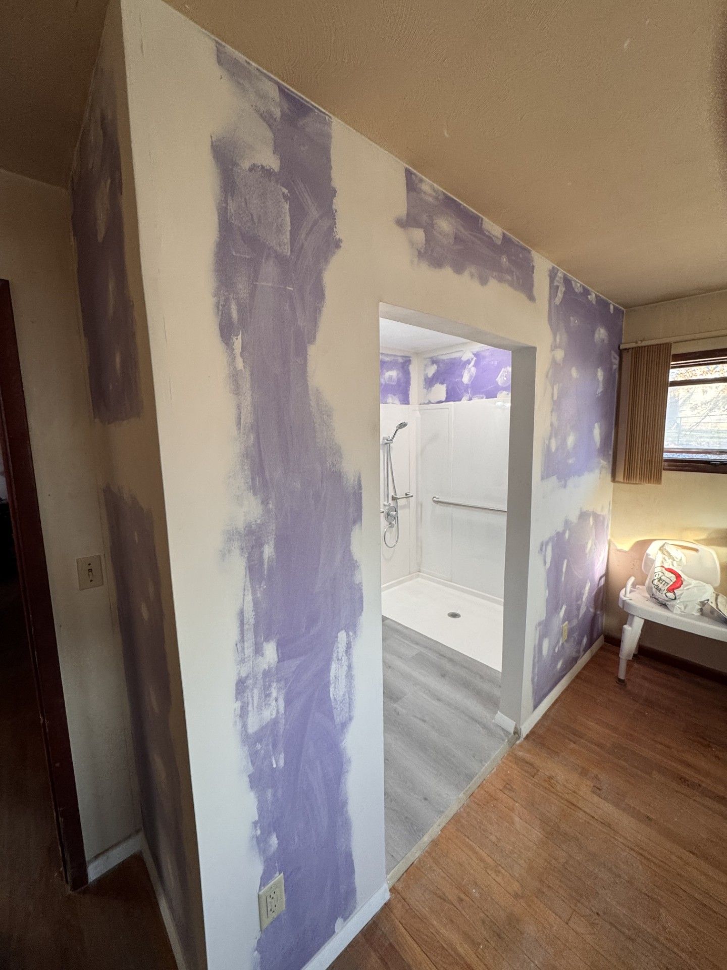 A corner of a room with drywall walls and a ceiling.