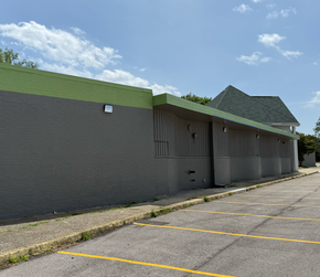 Exterior view of industrial building with blue overhead doors and a metal facade.