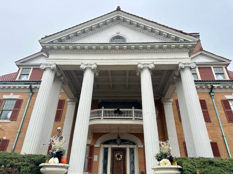 A large brick house with four white columns in the front
