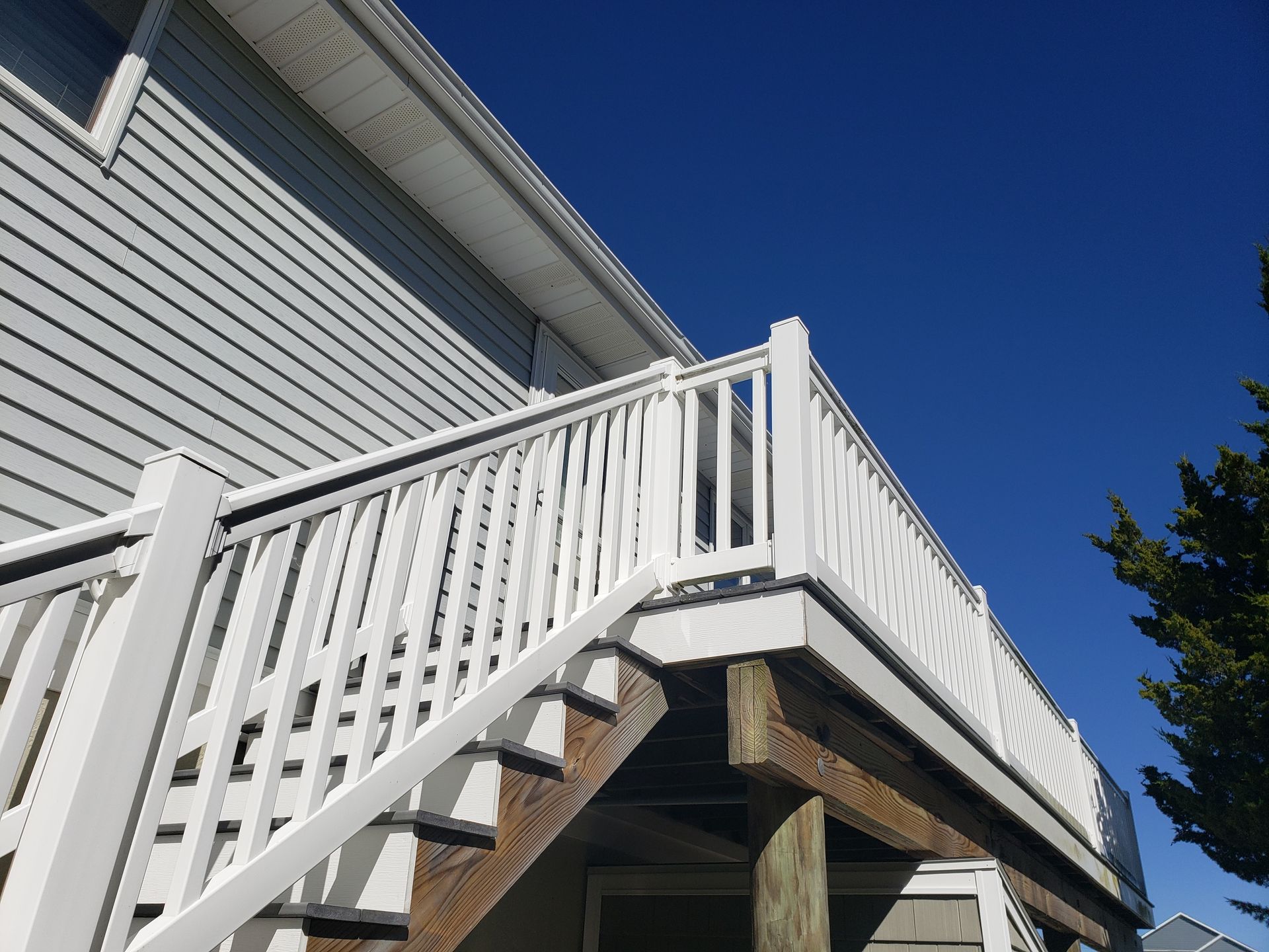A white deck with stairs leading up to it