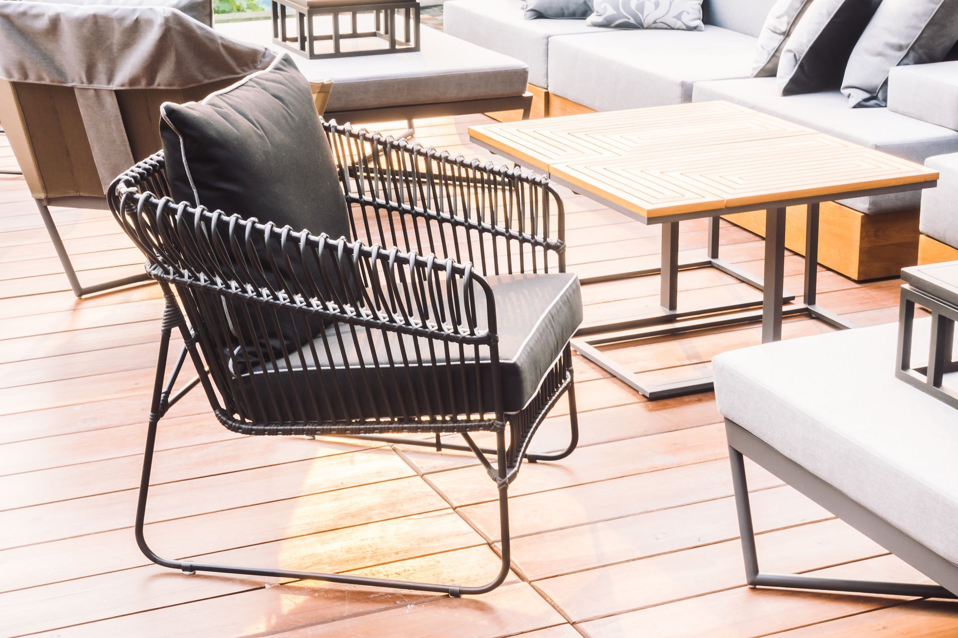 A chair is sitting on a wooden deck next to a table.