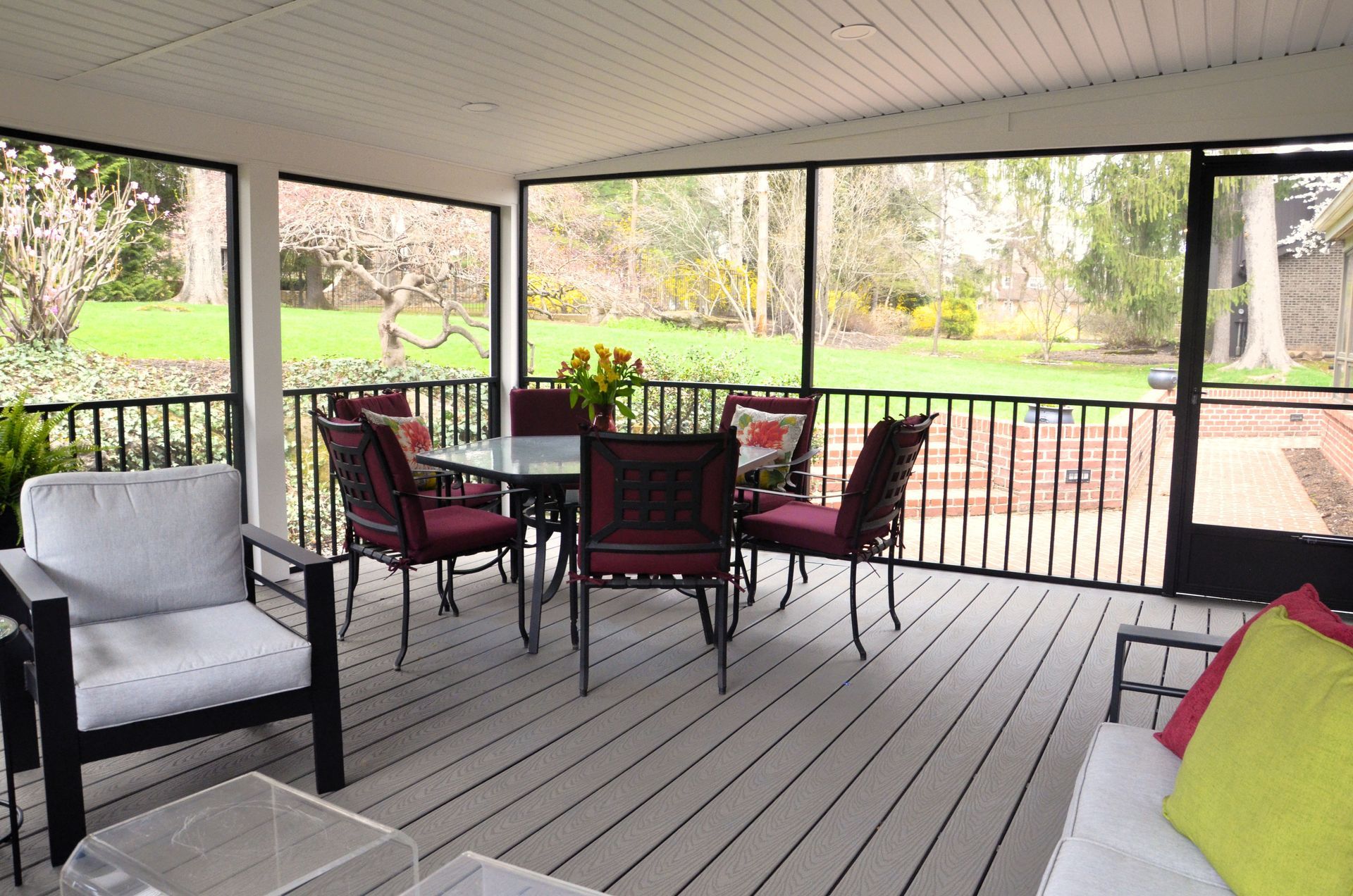 A screened in porch with a table and chairs