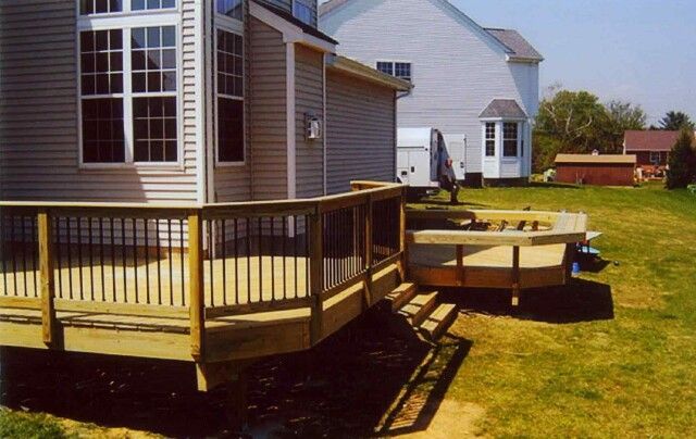 A wooden deck is being built in front of a house