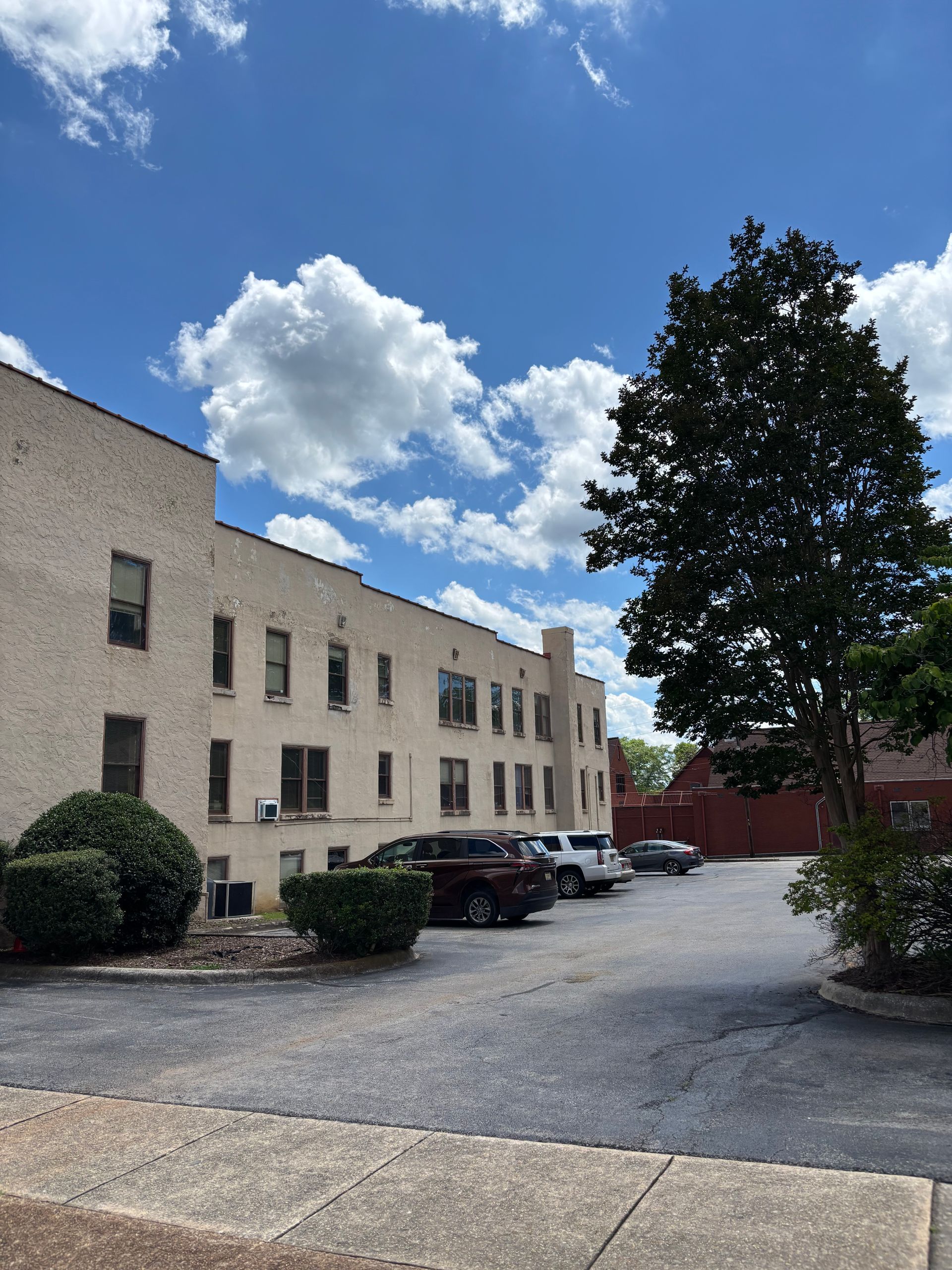 A building with cars parked in front of it on a sunny day