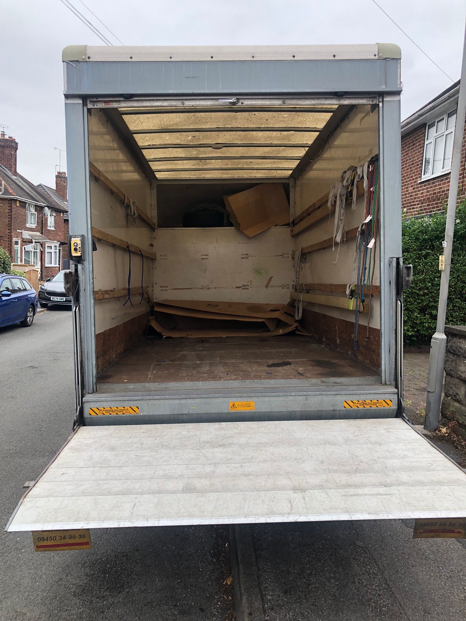 Open moving truck with ramp lowered, showing an empty cargo area inside.