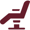 A red icon of a dental chair on a white background.