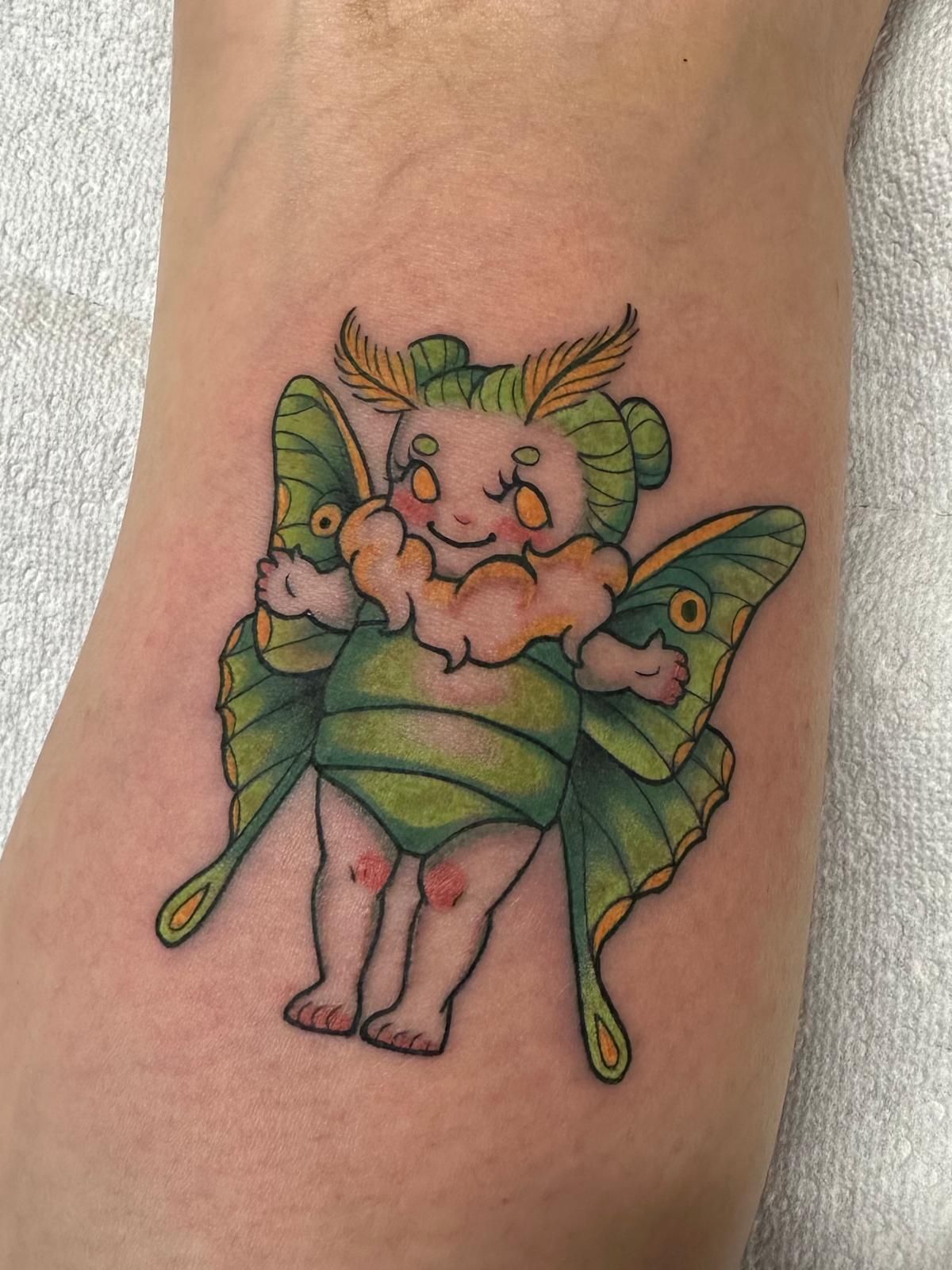 A tattoo of a baby moth on a person 's leg.