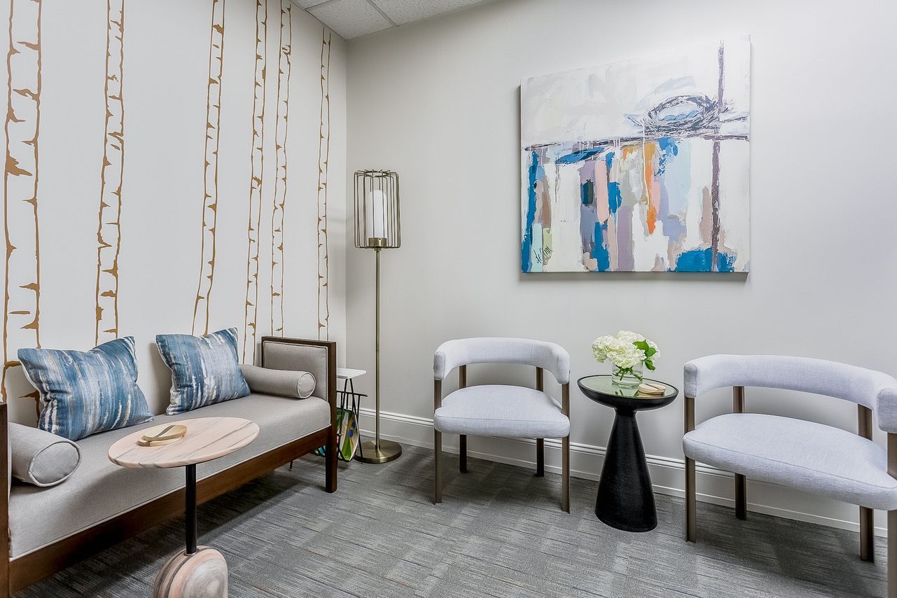 Dr. Sehon's waiting area with calm subtle colors, abstract art and birch tree trunks on a wall.