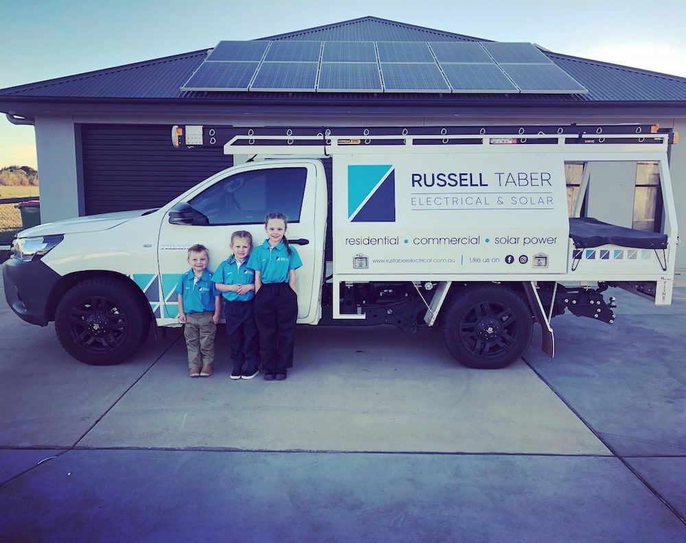 Three Children Are Standing in Front of a Russell Taber Truck — Russell Taber Electrical & Solar in Lake Albert, NSW
