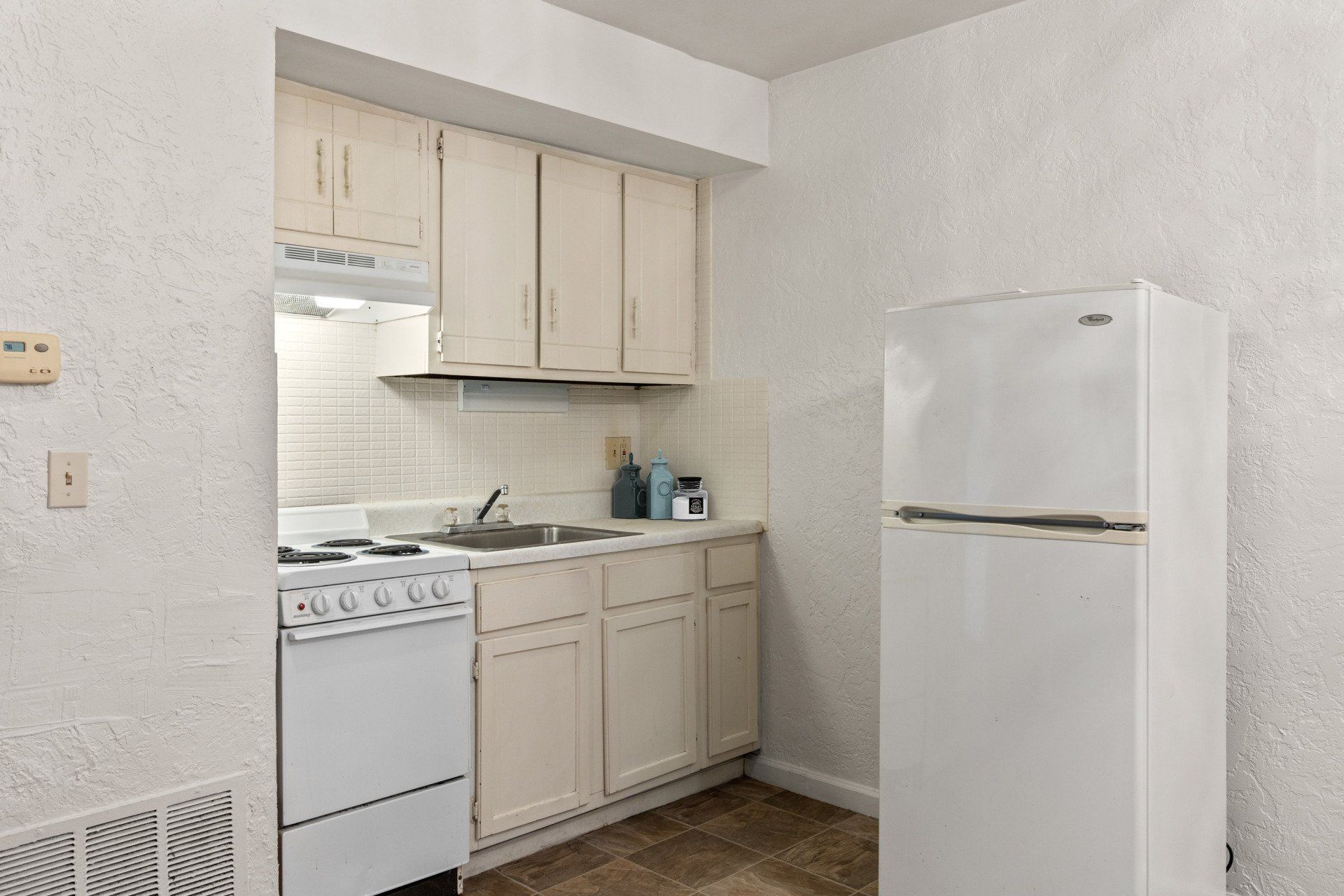 Kitchen with light cabinets and stove.
