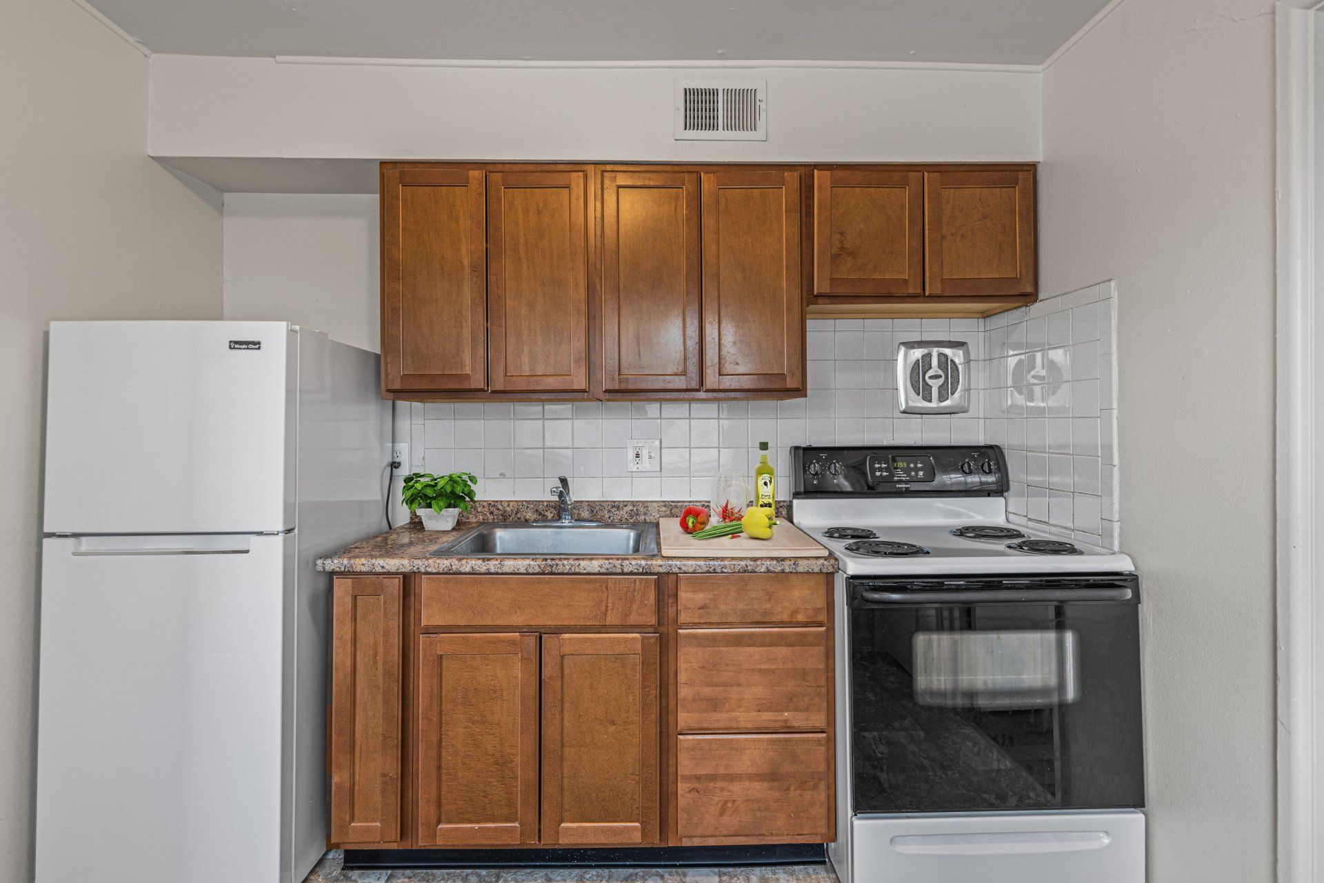 Charbonier Apartments kitchen with light wooden cabinets.